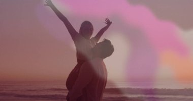 Gün batımında sahilde siluet kaldıran bir çift kadın, okyanus dalgalarıyla birlikte. Romantizm, aşk, huzur, siluet, macera, açık hava, canlı