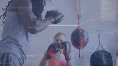 Antrenör bayan boksöre formda kalmayı ve fitness stüdyosunda boks becerilerini geliştirmeyi öğretiyor. Küresel iş bağlantıları dijital arayüz ve teknoloji konsepti dijital olarak oluşturulmuş video.