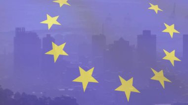 Şehir siluetinde kaybolan on iki sarı yıldızlı halka çerçeve görüntüsü için dönüyor ve parlıyor. Kozmoloji, kentsel, alacakaranlık, siluet, göksel, soyut, panorama