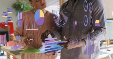 İş arkadaşları ofislerinde doküman yerleştiriyor, işletme bar çizelgeleri sergiliyor ve ölçümleri doğruluyor. İşbirliği, veri görselleştirme, iş analizleri, modern çalışma alanı, profesyonel, takım çalışması, dijital arayüz