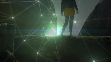 Yürüyüşçü kanyon çıkıntısına adım atıyor ve teknoloji demosu için parlayan bir ağı lens fişekleriyle etkinleştiriyor. Macera, teknoloji, yenilik, keşif, vahşi doğa, dijital, fütüristik