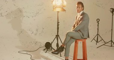 Dik oturmaya başlıyorum, erkek modeller, stüdyo moda çekimlerinde pozisyon değiştiriyor, takım elbise yakasını düzeltiyorum. Profesyonel, moda, tımar, minimalist, zarafet, tarz, portre