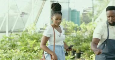 Müşteri bitki bakımı sorusu soruyor, bahçıvanın akıllı telefonu çevirmesi ve saksı bitkisini kaldırması. Botanik, bahçıvanlık, doğa, çevre, büyüme, refah