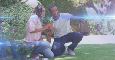 Adam akıllı telefonu ayarlıyor ve kadın çimlere saksı yerleştiriyor, bahçe selfie 'si çekiyor. Bahçe, doğa, yaşam tarzı, açık hava, sükunet, yeşillik, mutluluk