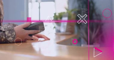 Asker akıllı telefonu ahşap tezgaha yerleştiriyor, terminali dinliyor, satışı pembe grafiklerle işliyor. Güvenlik, teknoloji, dijital, işlem, ticaret, iletişim, yenilik