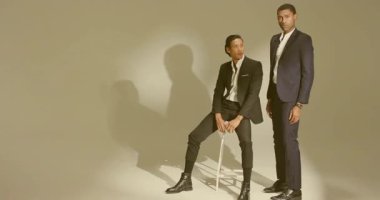 Moda çekimleri modelleri oturmaktan ayakta durmaya geçer. Fotoğrafçı sinyalleri üstüne tabure ile poz verir. Minimalist, içe dönük, sofistike, tek renkli, profesyonel, dinamik, zarif