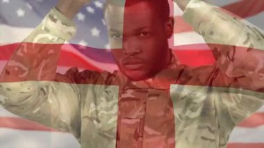 Askeri asker miğferi kavramak için kollarını kaldırıyor, bayraklar altında güvenlik için kayışları sıkılaştırıyor. Vatanseverlik, disiplin, dayanıklılık, güç, kararlılık, birlik, eylem