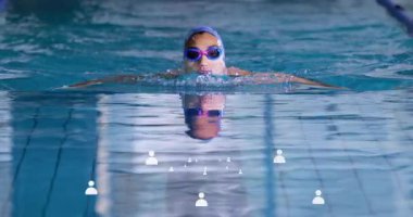 Yüzücü bilardoyu kepli, gözlüklü, kurbağalama çekmeli, yüzme turu çalışmalı. Sporcu, su sporu, hareket, eğitim, serbest stil, spor, su