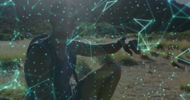 Çömelmiş atletizm yürüyüşçüleri çalılık vadide ileriyi işaret ediyor. Sırt çantası ve ukala ile, kopyalama alanı. Açık hava, macera, fitness, teknoloji, keşif, manzara, sağlık