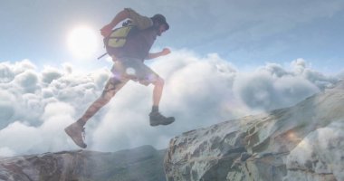 Beyzbol şapkası takan, yürüyüş botu giyen, sırt çantalı, bulut denizi üzerinde dağ sırtlarını aşan bir yürüyüşçü. Macera, keşif, engebeli, vahşi doğa, yükseklik, zirve, dayanıklılık