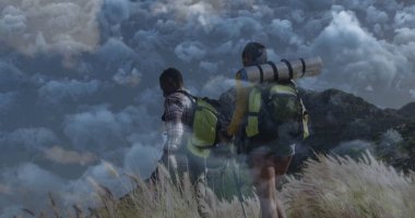 Tırmanışçılar, sırt çantaları, yürüyüş direkleriyle, uyku yastıklarıyla çimenli dağ yamacına tırmanıyorlar. Macera, keşif, vahşi doğa, açık hava, engebeli, yolculuk, yürüyüş