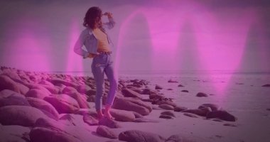 Kot ceketli çıplak ayaklı kadın, yuvarlanmış kot pantolon kayalık kıyılarda şişe kaldırma, fotokopi alanı. Sahil, açık hava, rahat, sakin, manzaralı, doğal, yaşam tarzı