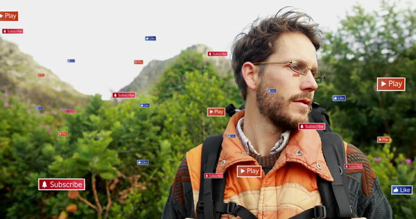 Standing man wearing glasses, orange jacket, carrying black backpack on hillside with digital icons. Adventure, exploration, wilderness, technology, outdoor, hiking, nature