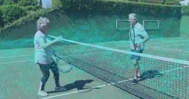 Üst düzey tenis çifti kil sahada şebeke gösterisine başlayıp beşlik çakıyor. Yaşlılar, eğlence, spor, bağlantı, iletişim, açık hava, canlılık