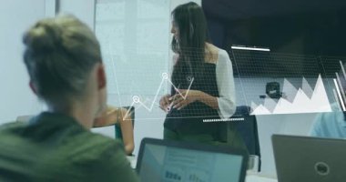 Sunucu, iş toplantısına liderlik eden el kaldırıyor, çizelge ve haritalara çizgi çiziyor. İşbirliği, analitik, veri görselleştirme, takım çalışması, kurumsal, profesyonel, modern