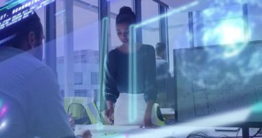 Ayakta duran kadın plan çiziyor ve holografik veri hatlarını aktifleştiriyor, erkek iş için verileri gözden geçiriyor. İşbirliği, yenilik, teknoloji, veri görselleştirme, takım çalışması, kurumsal, gelecekçi