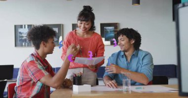 Ofis çalışanı iş arkadaşlarına yaklaşıyor ve belge sunuyor, iş analizi başlatılıyor. İşbirliği, takım çalışması, tartışma, şirket, sunum, iletişim, modern