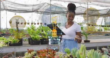 Sera yöneticisi elinde tablet tutarken leziz ürünleri incelerken AR ekranını aktifleştiriyor. Bahçecilik, teknoloji, yenilik, botanikçi, modern, çevre dostu, tarım