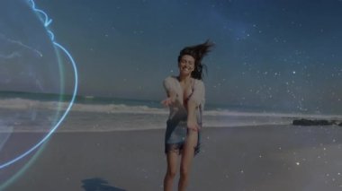 Sahilde dans eden ve kameraya doğru yürüyen bir kadın teknolojideki bağlantısını göstermeye başlıyor. Fitness, zindelik, zindelik, gezgin şehvet, rahatlık, dinginlik, dijital