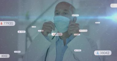 Kıdemli doktor sosyal medya bildirimleri alıyor ve hasta güvenliği için cerrahi maske ayarlanıyor. Tıbbi, sağlık, güvenlik, profesyonel, dijital, teknoloji, iletişim