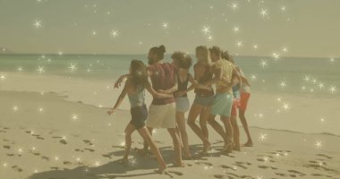 Kumlu sahilde kollarını birleştiren sahilde yürüyen yedi arkadaş ayak izleri ve okyanus suyu gösteriyor. Topluluk, rahatlık, rahatlama, tatil, açık hava, arkadaşlık, kaygısız