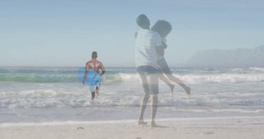 Kumsalda kumların üzerinde, turkuaz şortlu sörfçülerin üzerinde mavi bir badiba taşıyan bir çift. Romantizm, macera, eğlence, dinginlik, açık hava, canlılık, yaşam tarzı