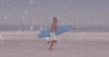 Koşan sörfçü şort giyiyor ve dalgalı mavi sörf tahtası taşıyor. Macera, sahil, canlı, dinamik, açık hava, atletik, boş zaman