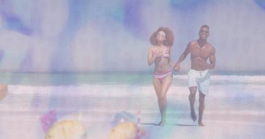 Koşan çift, kumlu sahilde ananas içecekleriyle birlikte pembe bikinili beyaz şort giyiyor. Romantik, boş zaman, varış yeri, tropikal, canlı, yaşam tarzı, aktif