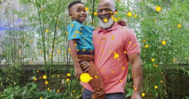 Dedem torunu su dolu teneke filtreyle kaldırıyor bambu etrafında dönen altın parçacıkları ekliyor. Aile, akıl hocalığı, şefkat, canlılık, açık hava, uyum, kutlama