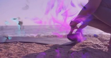 Mor mavi enerji girdabında sallanırken, kadın paspas tutan, saat takılı yoga minderi yuvarlıyor. Macera, sağlık, sükunet, canlılık, performans, esneklik, açık hava