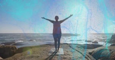 Dişi yogi paspasa basıyor, sağlık için okyanusun doğuşunda kayalık çıkıntıda güneş selamı veriyor. Meditasyon, sağlık, huzur, manzara, fitness, farkındalık, doğal