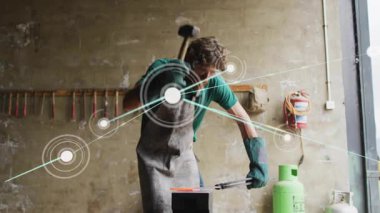 Kızgın metali kavrayıp çekiç kaldıran demirci ağı genişleterek metali dövüyor. İşçilik, endüstriyel, yaratıcı, mühendislik, kılavuz, yenilik, atölye