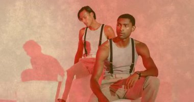 Dairesel kırmızı projeksiyonu takip eden iki erkek model ve pazarlama çekimi için ayarlama pozisyonu. Düşünce, estetik, minimalizm, siluetler, projeksiyonlar, ahenk, sofistike