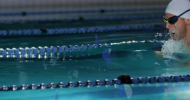 Erkek sporcu bilardo duvarından itiyor ve şerit ayırıcılarıyla spor antrenmanında kurbağalama ile süzülüyor. Su, dayanıklılık, atletizm, aerodinamik, fitness, rekabet, spor