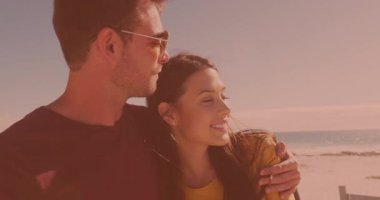 Kumsalda birbirini kucaklayan mutlu beyaz bir çift. Çift, ilişki ve tatil kavramı