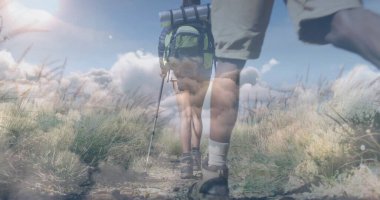 Yürüyüşçülerin alt gövdeleri, sırt çantası ve yürüyüş direğiyle dar toprak yollarda geziniyor. Macera, keşif, vahşi doğa, açık hava, yürüyüş, doğa, yolculuk