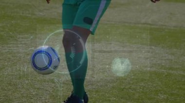 Futbol oyuncusu sahada topa vurup hokkabazlık yaparken HUD de spor analizi için topu takip ediyor. Atletik, performans, dinamik, teknoloji, açık hava, fitness, hareket