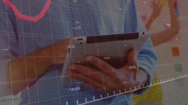 Office worker tapping tablet showing red graph for tracking tech data as colleague arranging notes. Technology, collaboration, data, innovation, brainstorming, analysis, digital