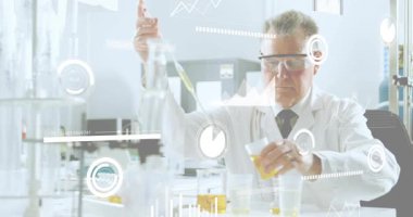 Üst düzey bilimadamı pipet kaldırıyor ve laboratuvar analizi için sıvı çıkarıyor ve veri tabloları üst üste konuyor. Araştırma, kesinlik, deney, yenilik, bilimsel, analiz, teknoloji