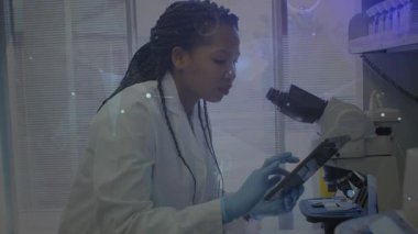 Bilim araştırmacısı veri için tablet araklıyor ve mikroskop oluşturup analiz örtüleri oluşturuyor. Laboratuvar, yenilik, biyokimya, yüksek teknoloji, analiz, deney, fütüristik