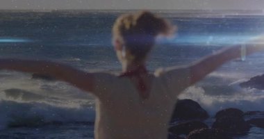 Female loosening hair tie and releasing cascading waves as facing sunset sea to capture travel mood. Serenity, freedom, elegance, coastal, tranquility, natural, contemplative