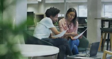 Adam yazılı belgeyi işaret ediyor ve iş takımını tartışırken kadını dizüstü bilgisayara yönlendiriyor. İşbirliği, takım çalışması, tartışma, profesyonel, iletişim, modern, ofis