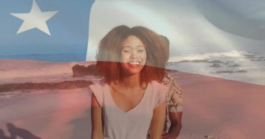 Kadın kumsalda gülümserken erkek bayrak grafiğiyle pazarlama için ona sarılıyor. Romantizm, şefkat, açık hava, yaşam tarzı, mutluluk, eğlence, çeşitlilik