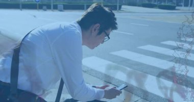 Adam akıllı telefon kullanıyor, grafik ambalaj şeritlerini çalıştırıyor ve beklerken çözülüyor. Teknoloji, bağlantı, kentsel, yenilik, dijital, iletişim, modernite