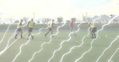 Kırmızı önlük koçu, beyaz topu iterek dönen oyuncuları sahada top sürerek sondaj yapıyor. Atletik, takım çalışması, antrenman, spor, hareket, açık hava, disiplin