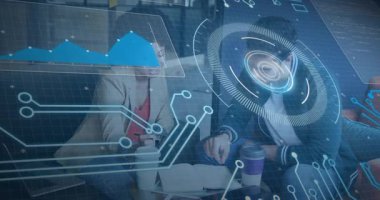 Not defterini işaret eden adama göre, meslektaşlar teknik verileri grafikle örtüşen notlarla analiz ediyorlar. İşbirliği, veri görselleştirme, fütüristik, yenilikçi, takım çalışması, analitik, dijital arayüz