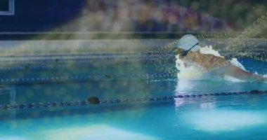 Yüzücü sağdan şeride giriyor, kurbağalama vuruşu yapıyor ve forma girmek için suyu itiyor. Spor, su sporu, performans, egzersiz, hareket, akıcılık, canlılık