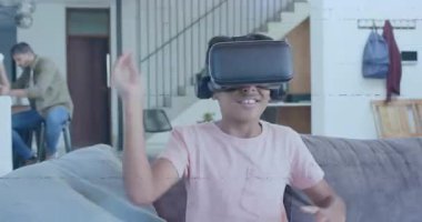 VR kulaklık takan bir çocuk mutfak adasında akıllı telefon kullanarak VR dünyasını keşfediyor. Teknoloji, aile, yenilik, eğlence, modernlik, etkileşim, eğlence