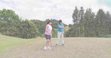 Eğitmen golf sopasını hizalıyor, girdap oluşturuyor öğrenci kavrayışını yansıtırken salıncak gösteriyor. Koçluk, akıl hocalığı, spor, açık hava, manzara, görselleştirme, teknik