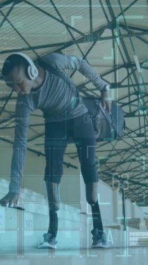 Su şişesi tutan ve kulaklık takan bir adam stadyumun üzerinde spor salonu animasyonu yapıyor. egzersiz, teknoloji, atlet, hidrasyon, koşu, koşu